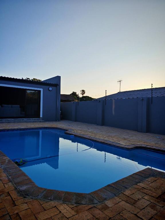 a swimming pool in the backyard of a house at Stylish Studio Room with Shared Pool Near Table View Beach in Cape Town
