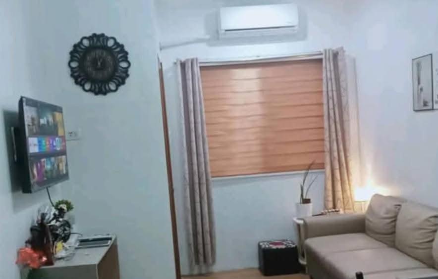 a living room with a couch and a window at Bayanihan flats Condo in Pajak