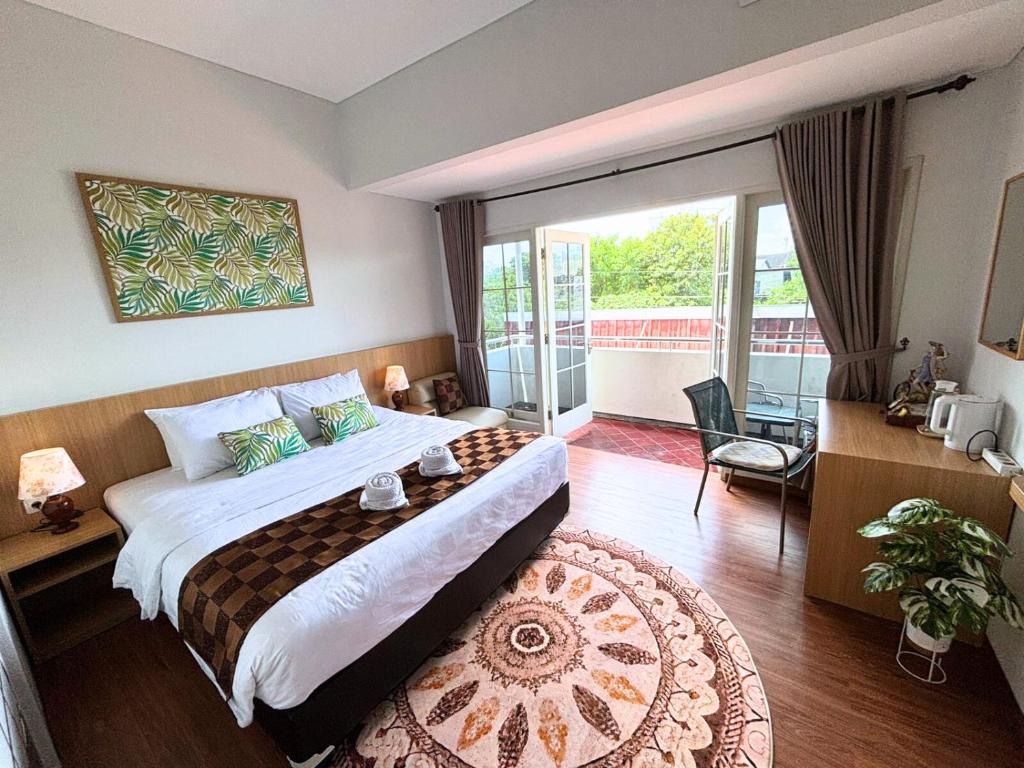 a hotel room with a bed and a large window at Florens Inn in Yogyakarta