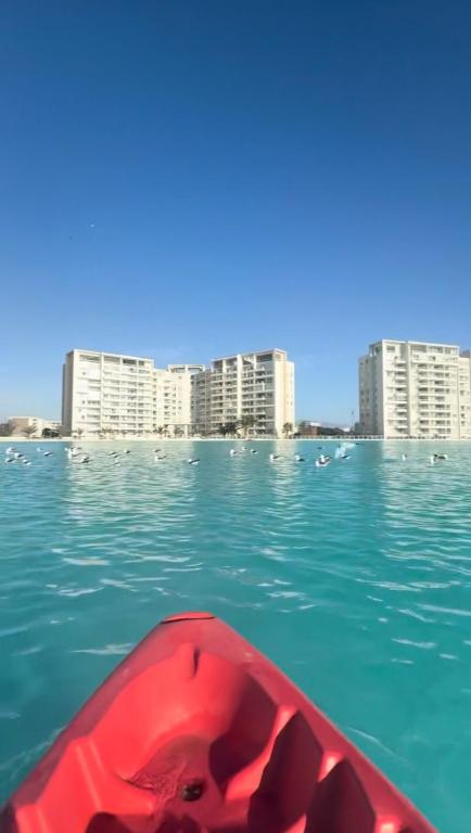 a red boat in the water in front of buildings at Laguna del Mar, C 208 in La Serena