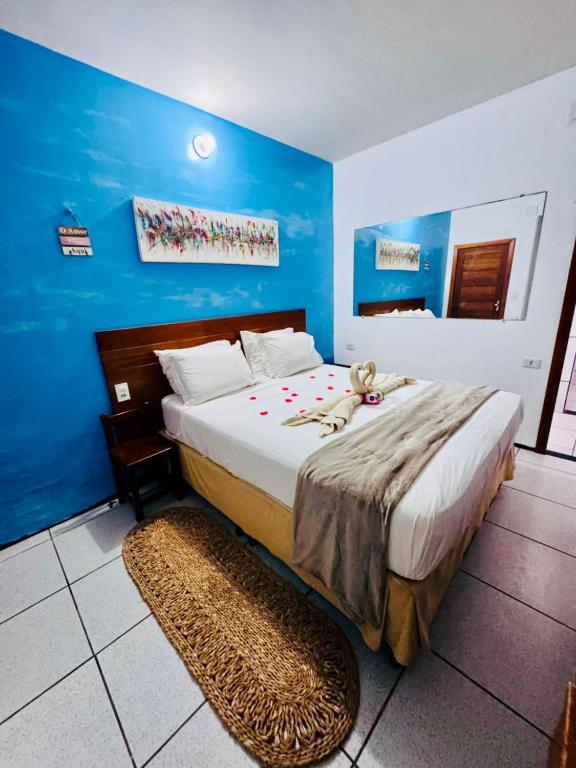 a bedroom with a bed with a teddy bear on it at Beach House Suítes Jeri in Jericoacoara