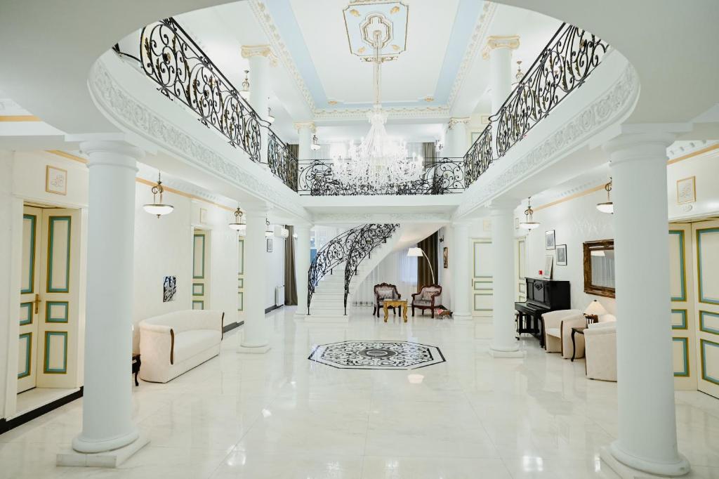 a large living room with white furniture and a chandelier at Hotel Jardin in Belgrade