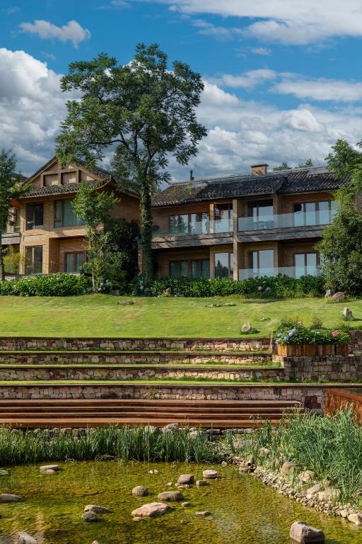 an apartment building with a pond in front of it at Evergreen Forest Retreat Zhangjiajie, Near National Forest Park Avator Park, Luxury Nature Escape, Free Airport&Train Shuttle Service & Travel itinerary, English Speaking Butler in Zhangjiajie