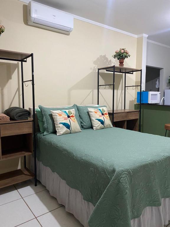 a bedroom with a bed with green sheets and pillows at chick nina in Barra do Garças