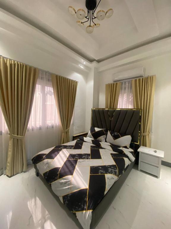 a bedroom with a black and white bed and windows at Mira Transient in Bantay