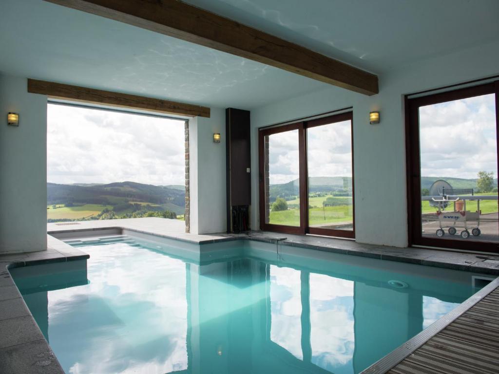 ein Swimmingpool mit Blick auf ein Haus in der Unterkunft Villa Les Charmes Premium villa for 20 guests in Habiemont
