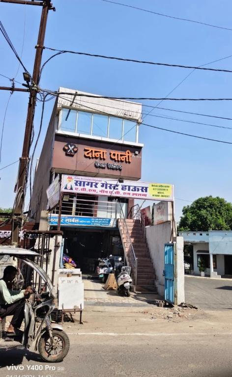 a man sitting on a motorcycle in front of a building at Sagar hotel and guest house in Sāgar