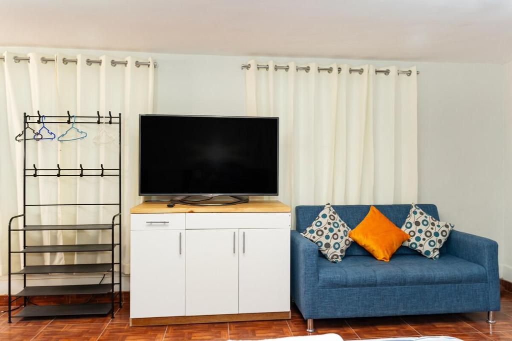 a living room with a blue couch and a flat screen tv at Nice Apartment in Urubamba in Urubamba