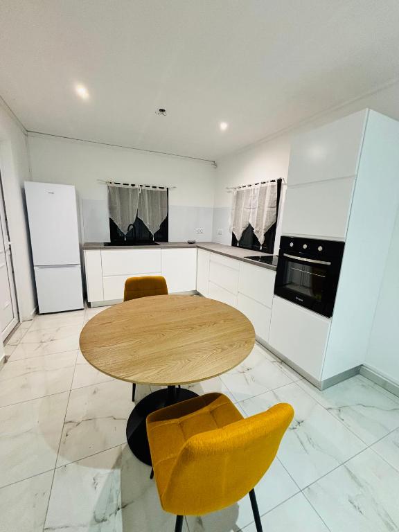 a kitchen with a wooden table and two yellow chairs at Golden DREAM Suites cocon modern in Capesterre-Belle-Eau