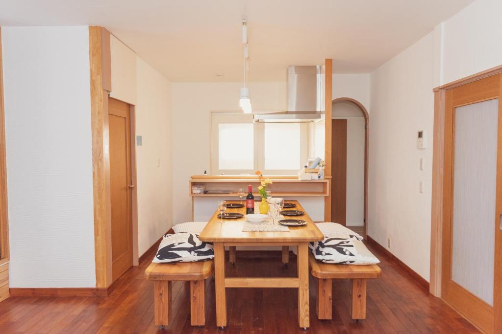 a kitchen with a wooden table in a room at 民泊八のや in Hachioji