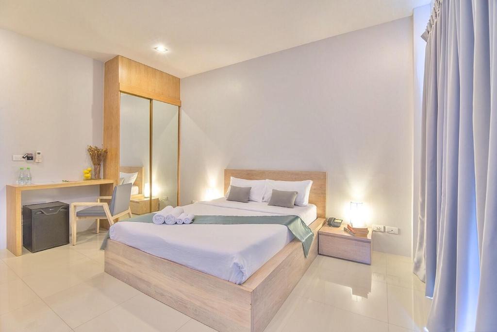 a bedroom with a bed and a desk in it at Lemonade Phuket Hotel -SHA Plus in Chalong