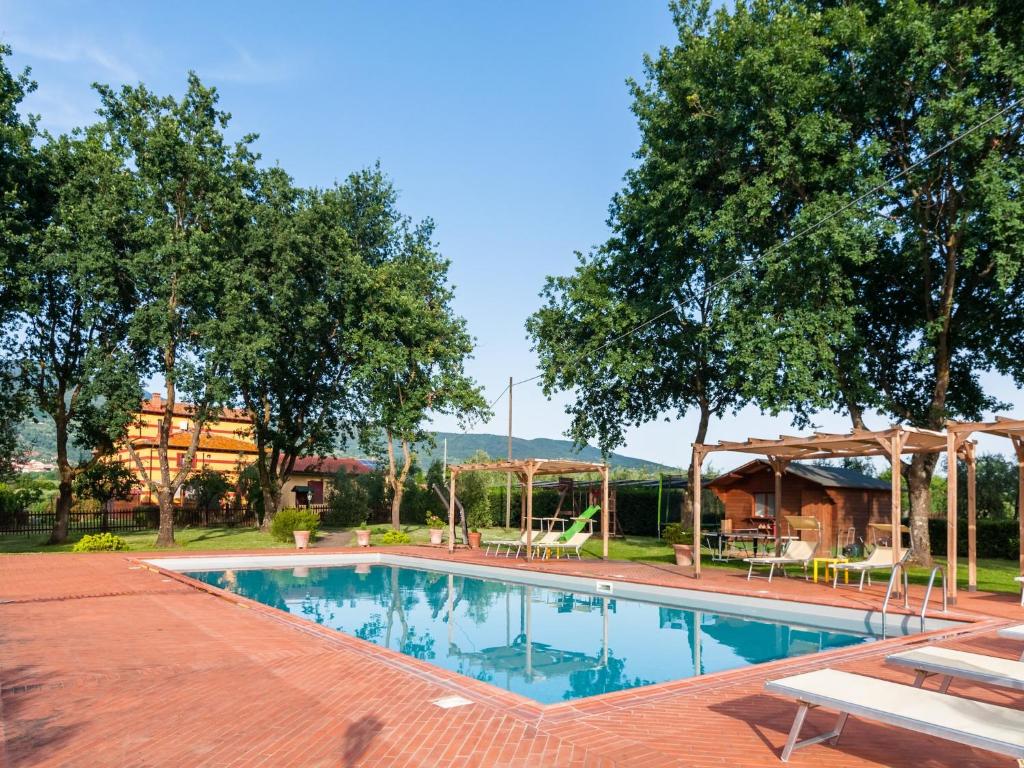 a swimming pool in a yard with trees at Mansion with Pool and play area in Pian di Scò