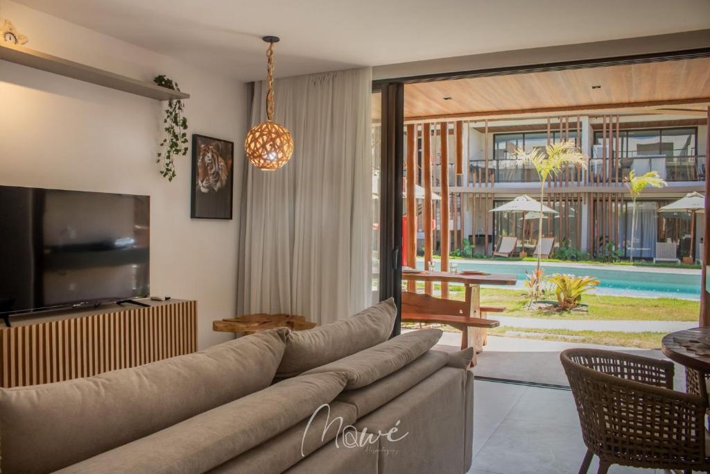 a living room with a couch and a tv at Naay - Sun 008 in Pôrto de Pedras