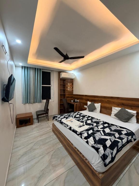 a bedroom with a large bed with a ceiling at Landlord Premier in Rohtak