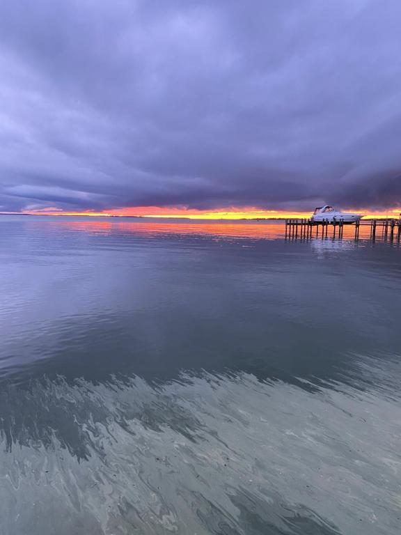 a view of the water with a pier in the background at Tiny House at Piney point in Piney Point