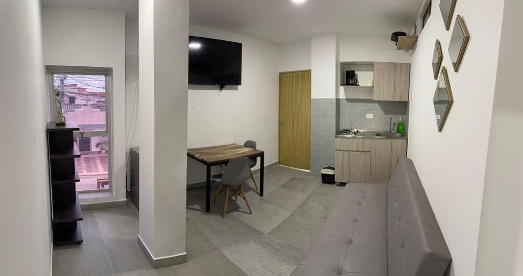 a living room with a couch and a table and a kitchen at Diplastic House in Sincelejo