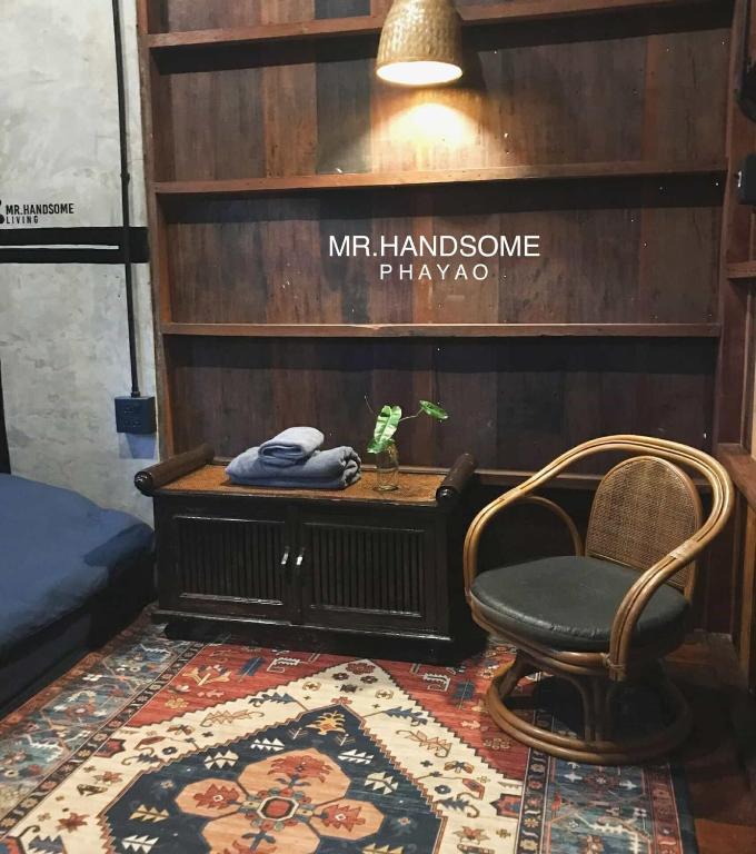 a room with a chair and a table and a rug at mr handsome phayao in Ban Mae Ka Hua Thung