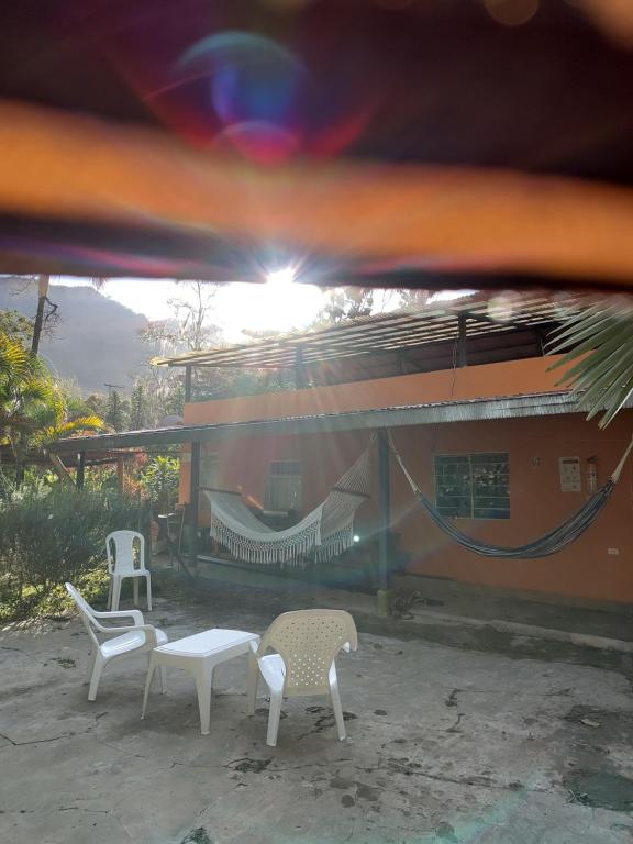 a group of chairs and a hammock outside of a house at Posada San Jorge in Pacho