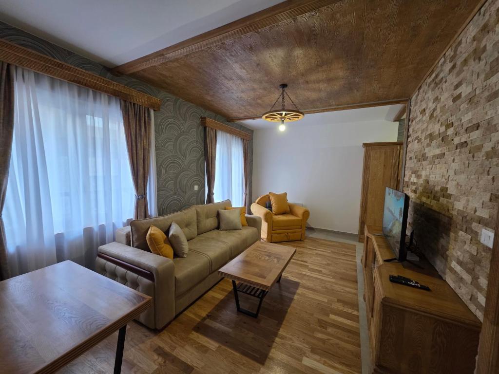 a living room with a couch and a tv at Arija Luxury Suite in Kolašin