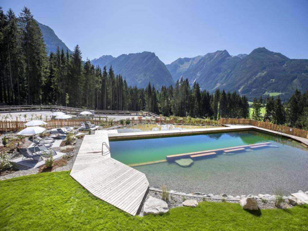 a large pool of water with mountains in the background at Alpine Chalet with Ski-In Access in Neukirchen am Großvenediger