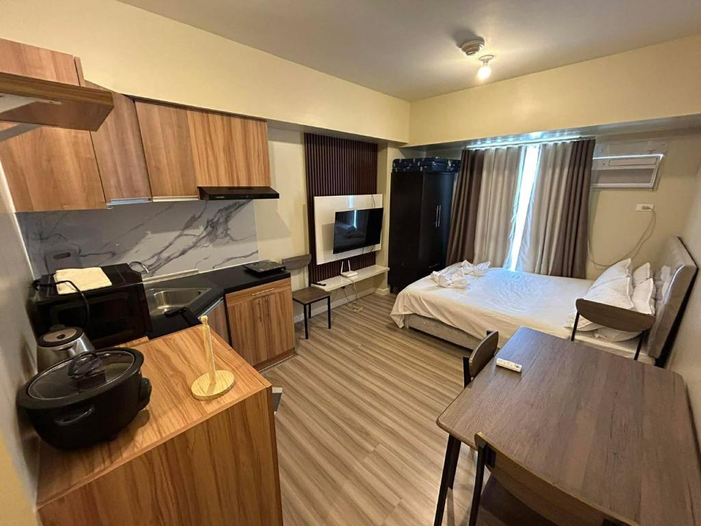 a small hotel room with a bed and a kitchen at Ann's Haven in Cebu City