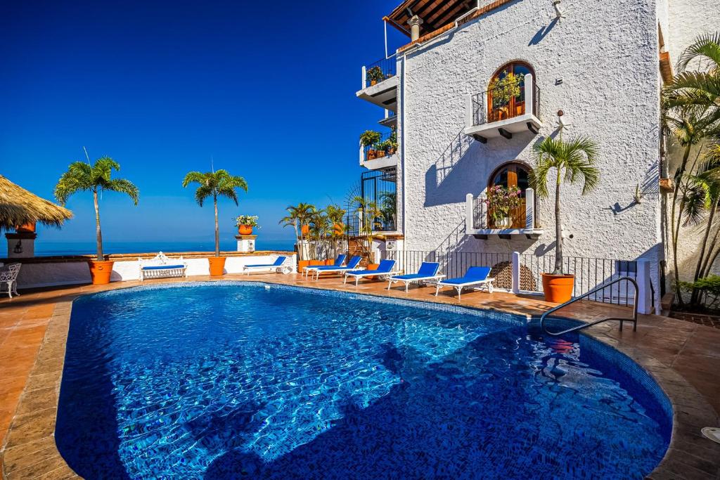 a villa with a swimming pool in front of a building at Charming condo featuring ocean views, pool & private terrace in Puerto Vallarta