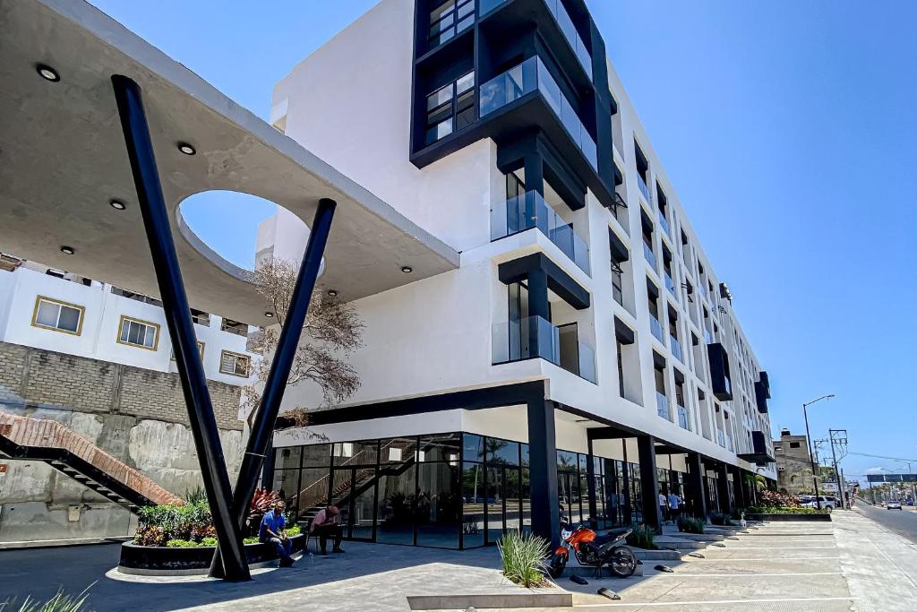 a building with people sitting outside of it at Ocean-view condo with infinity pool, rooftop lounge, & private balcony in Bucerías