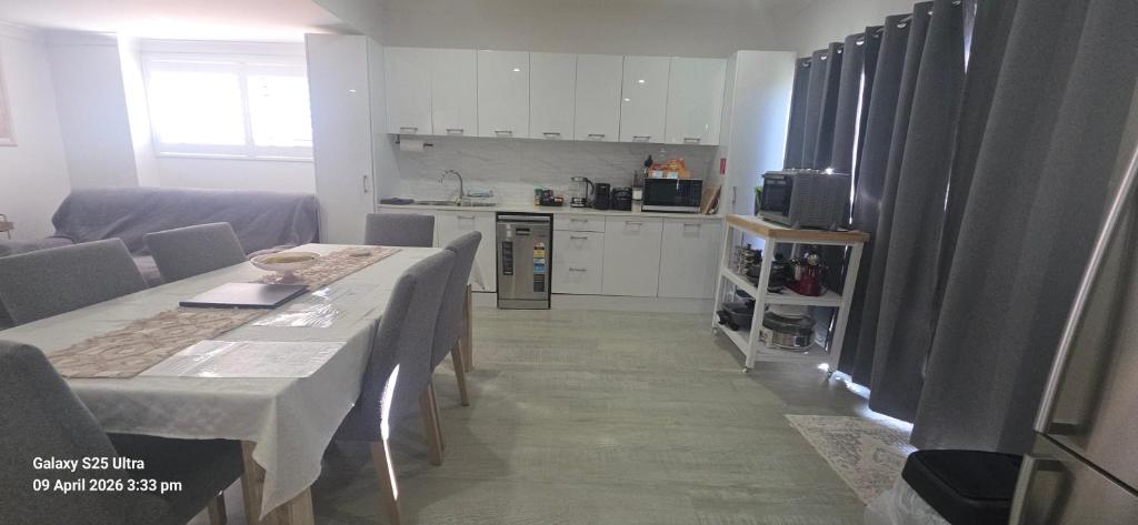 a living room with a table and a kitchen at Oscar's at Banora in Kurrara