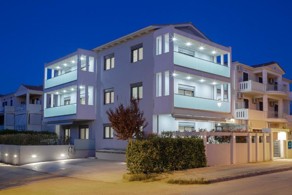 an apartment building with lights in the night at Carabella Residence in Lefkada