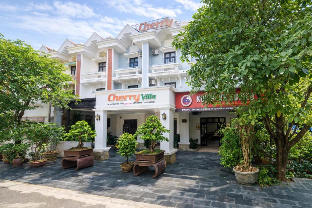 a white building with trees in front of it at Cherry Villa in Hue