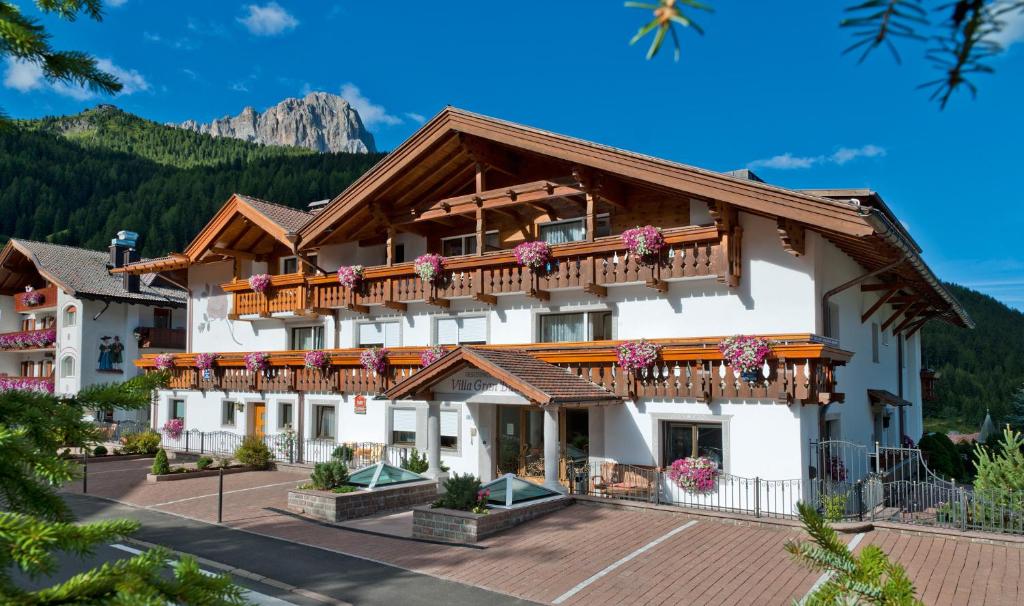 un hotel con balcón y montañas de fondo en Residence Villa Gran Baita en Selva di Val Gardena