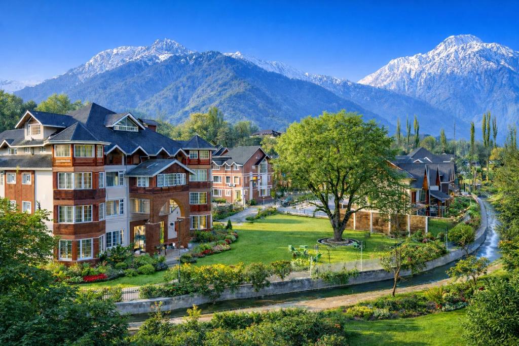 a row of houses with mountains in the background at Faiz Resort Pahalgam in Pahalgām