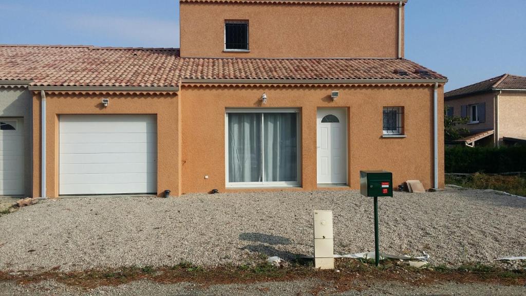 una casa con dos puertas de garaje y un parquímetro en Chambres d'hôtes Drome en Chatuzange-le-Goubet