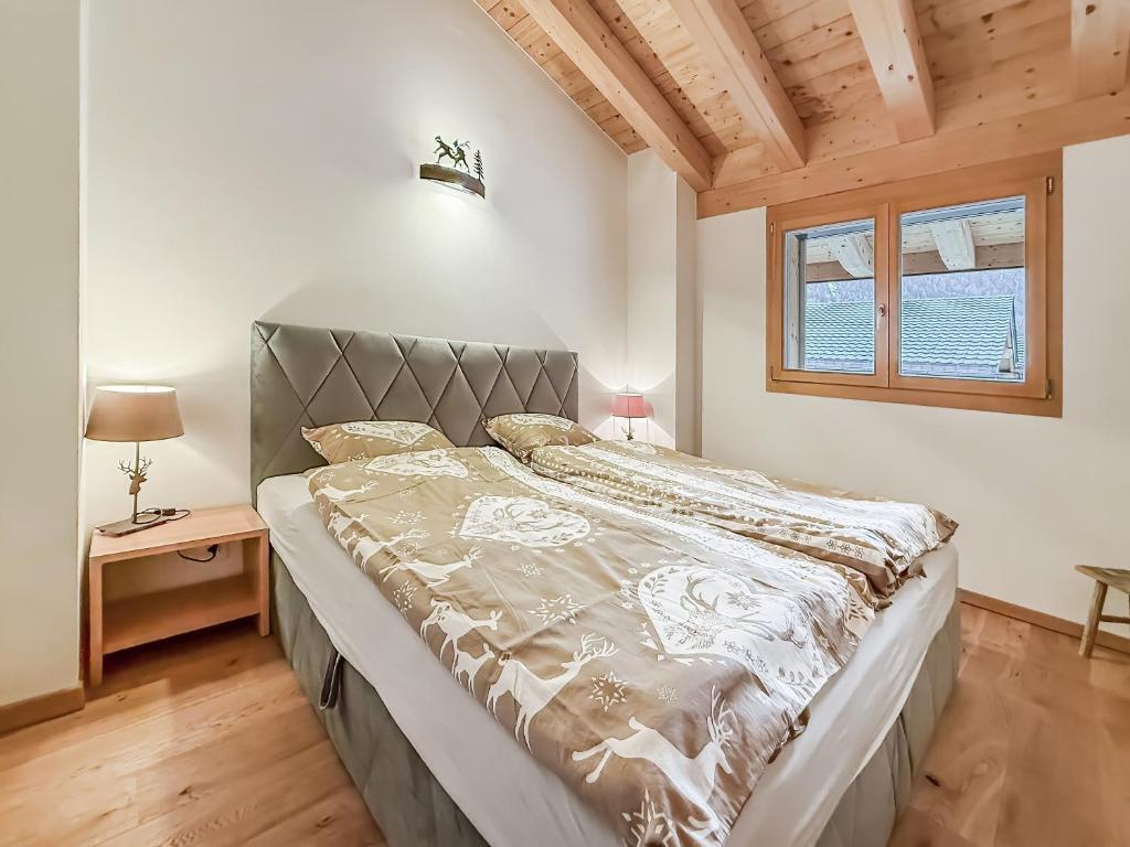a large bed in a bedroom with a wooden ceiling at Elevate in Ovronnaz