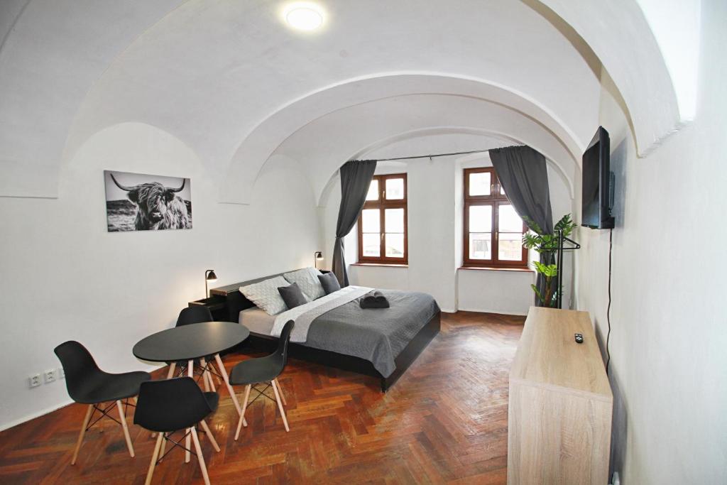 a bedroom with a bed and a table and chairs at Lacná izba v centre in Banská Bystrica