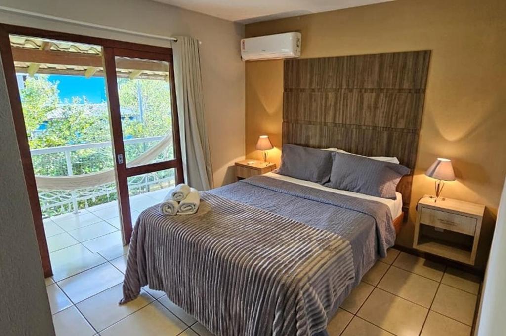 a bedroom with a bed and a balcony at Pousada Marina do Sol in Florianópolis