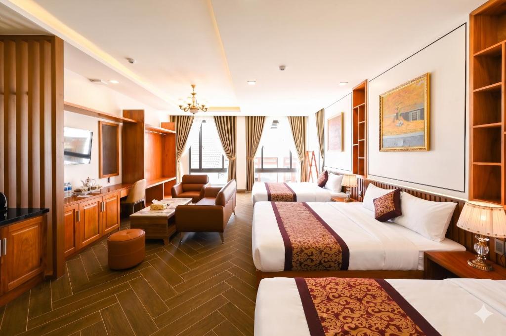 a hotel room with three beds and a bathroom at La Fleur Premium Central Apartment Hotel in Da Lat