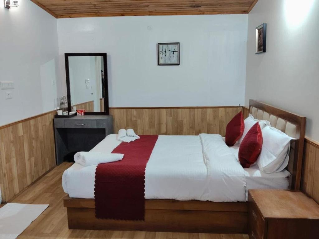 a bedroom with a large bed and a mirror at The Cup House in Namchi