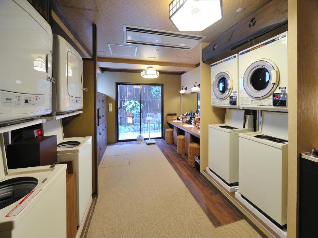 a kitchen with two washer and dryers and a hallway at Dormy Inn Akihabara in Tokyo