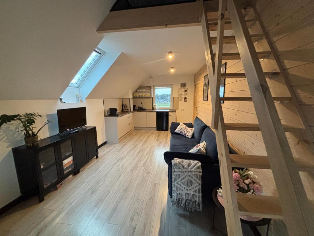 a living room with a staircase leading to a kitchen at Anielski Apartament z prywatną balią in Szaflary