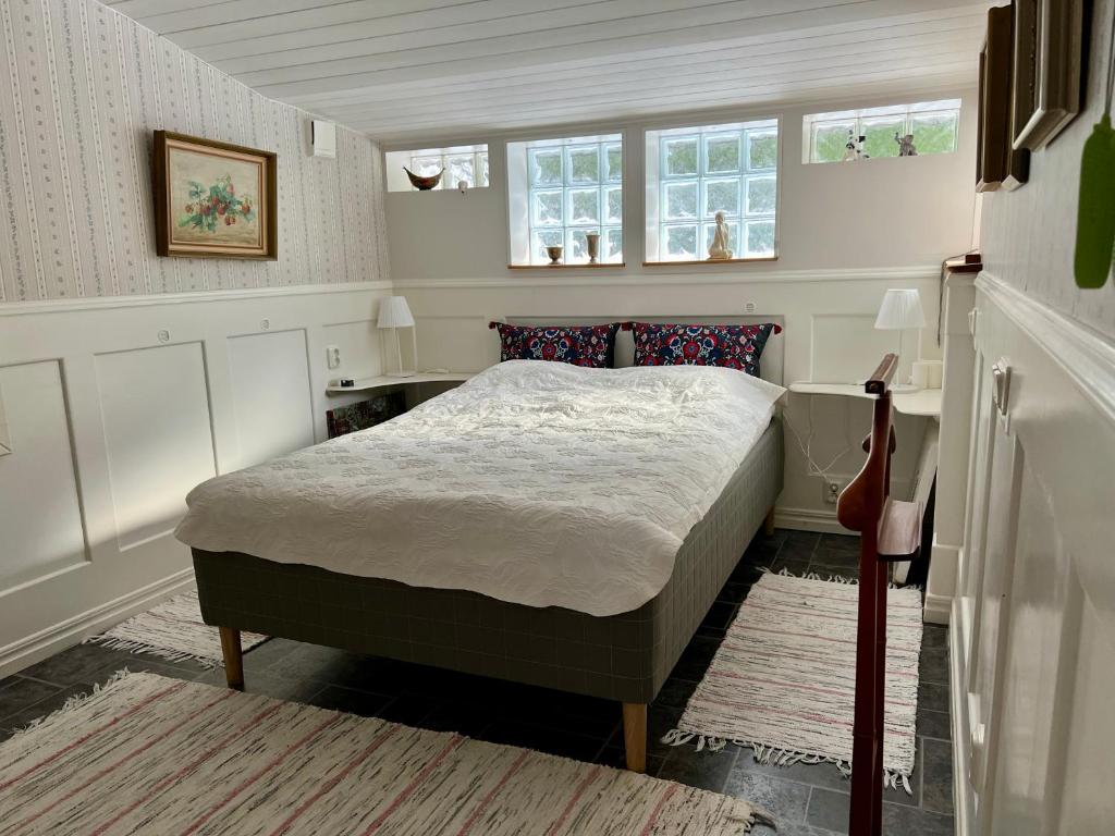 a bedroom with a bed and two windows at Trädgårdscafé Pedalen B&B in Halmstad