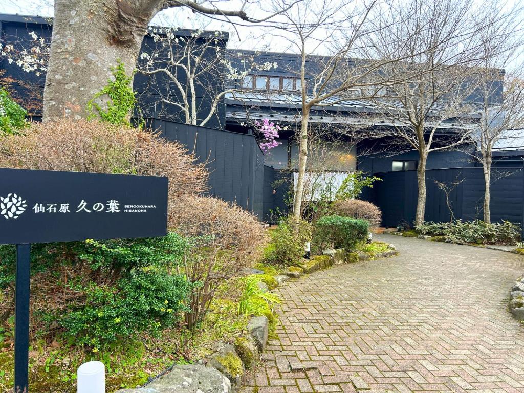 a sign in front of a building with a brick walkway at Sengokuhara Hisanoha in Hakone