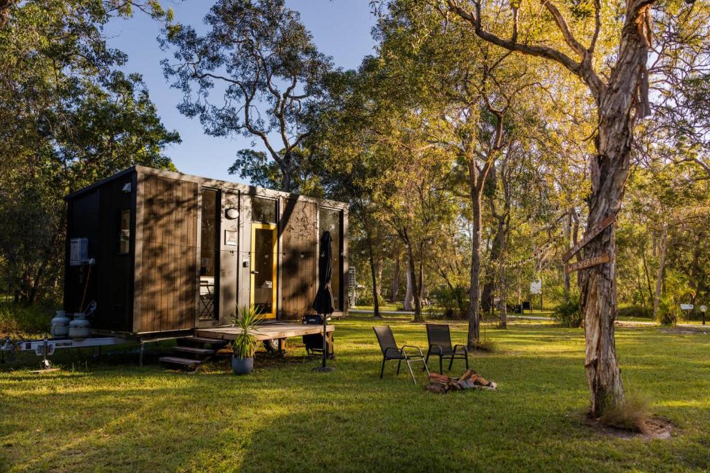 a tiny house in a park with a table and chairs at Wilderness Whisper 1770 By Tiny Away in Agnes Water