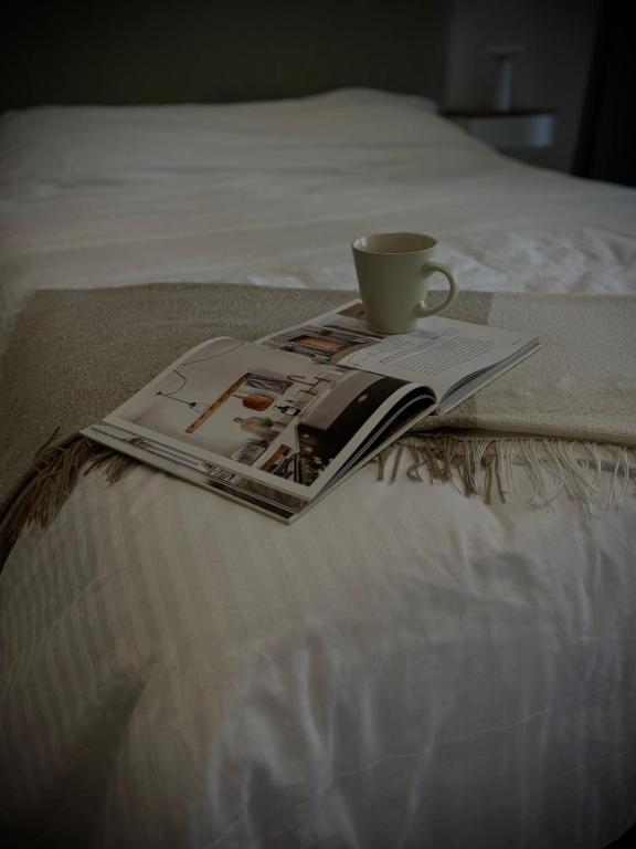 a book and a coffee cup on a bed with a magazine at CubeStudio21 in Kallithea Halkidikis