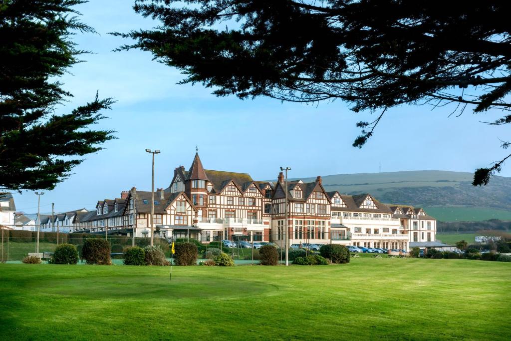 a large building on a golf course with a green at The Woolacombe Bay Hotel in Woolacombe