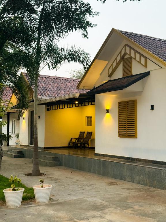 a house with a yellow and white facade at SRK luxe resort in Maivādi Road