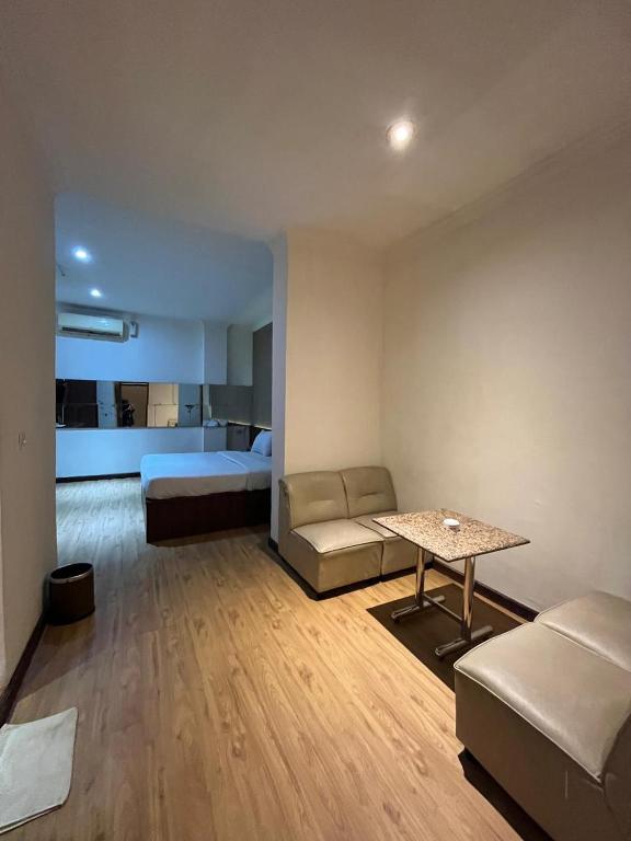 a living room with a bed and a table at Hotel Aruni Ancol in Jakarta