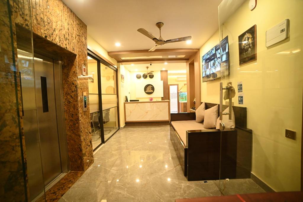 a living room with a couch and a ceiling fan at Eloras Inn in Siliguri