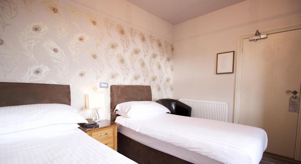 two beds in a small room with white walls at The Woolacombe Bay Hotel in Woolacombe