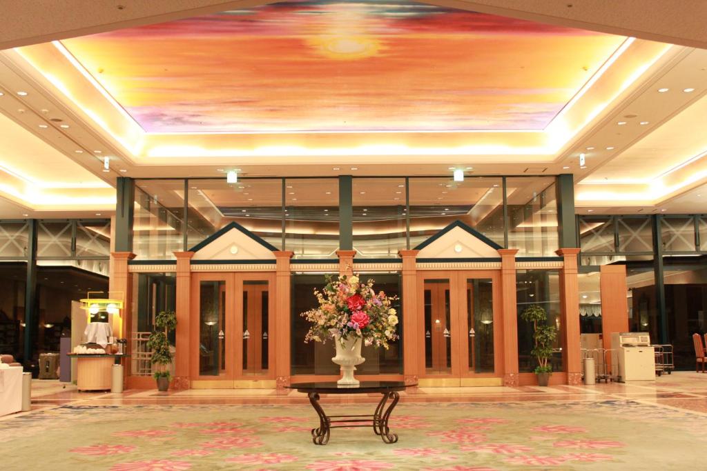 un hall d'entrée avec un vase de fleurs sur une table dans l'établissement Shiretoko Daiichi Hotel, à Shari